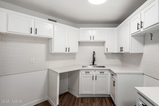 kitchen featuring white cabinetry, sink, light stone counters, and dark hardwood / wood-style floors