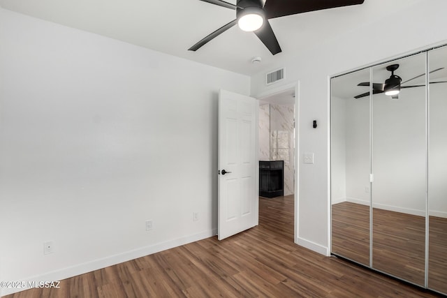 unfurnished bedroom with ceiling fan, hardwood / wood-style floors, and a closet