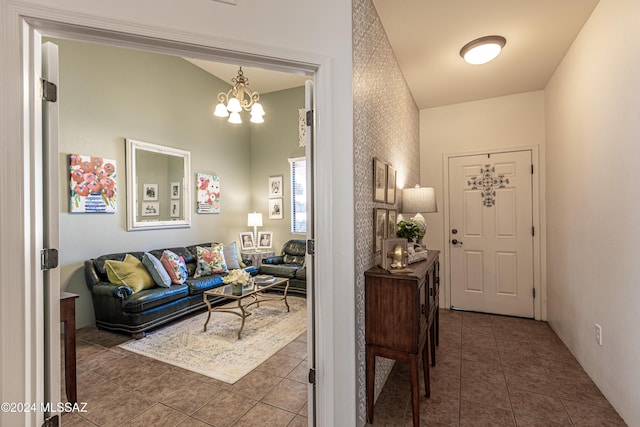 entrance foyer with dark tile patterned floors and a notable chandelier