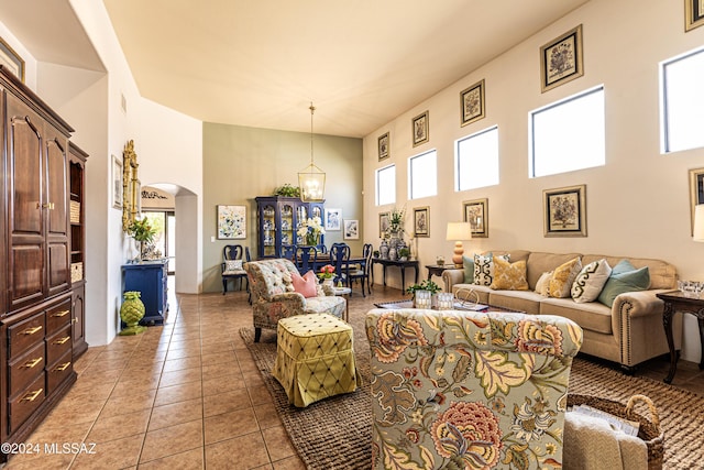 living room with a towering ceiling and light tile patterned floors