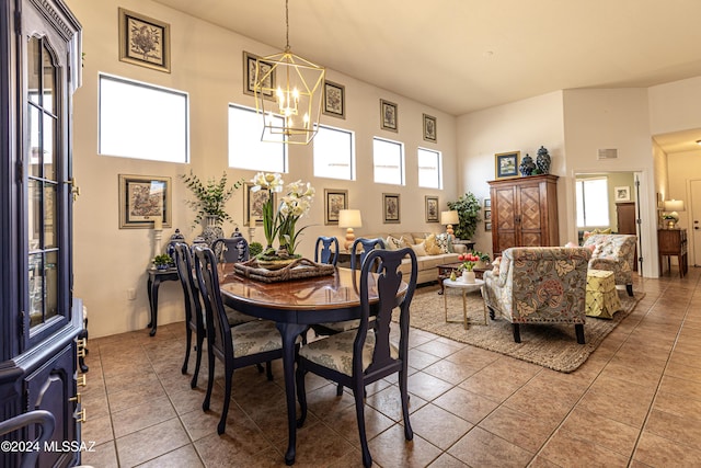 dining space with a notable chandelier, tile patterned floors, and a high ceiling