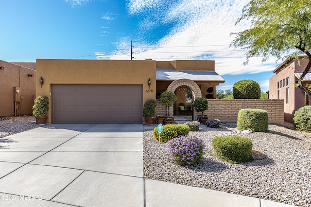 pueblo-style house featuring a garage