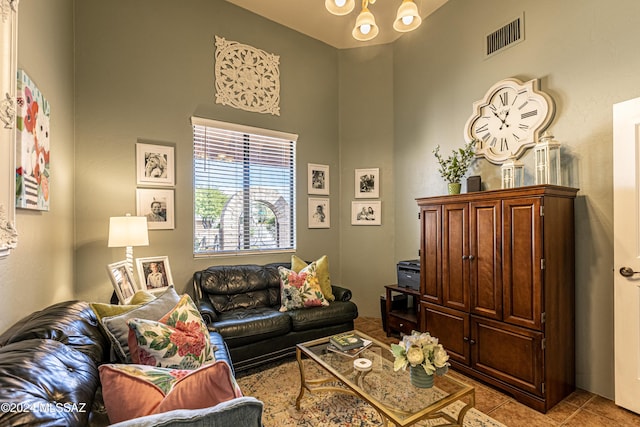 tiled living room with a notable chandelier