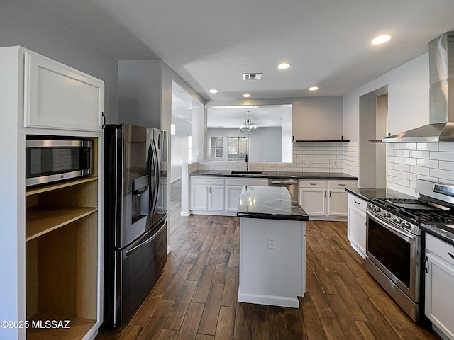 kitchen featuring white cabinetry, appliances with stainless steel finishes, sink, and wall chimney range hood