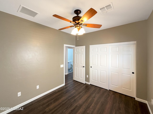 unfurnished bedroom featuring dark hardwood / wood-style floors, ceiling fan, and a closet