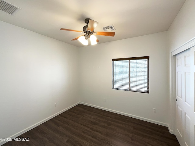 unfurnished bedroom with dark wood-type flooring, ceiling fan, and a closet