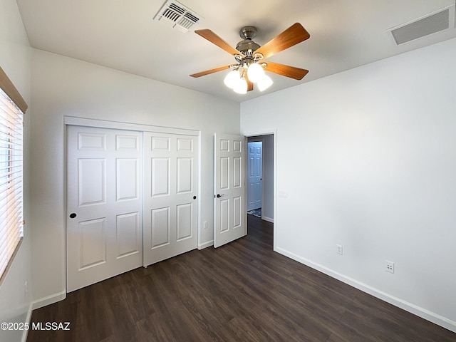 unfurnished bedroom with ceiling fan, dark hardwood / wood-style floors, and a closet