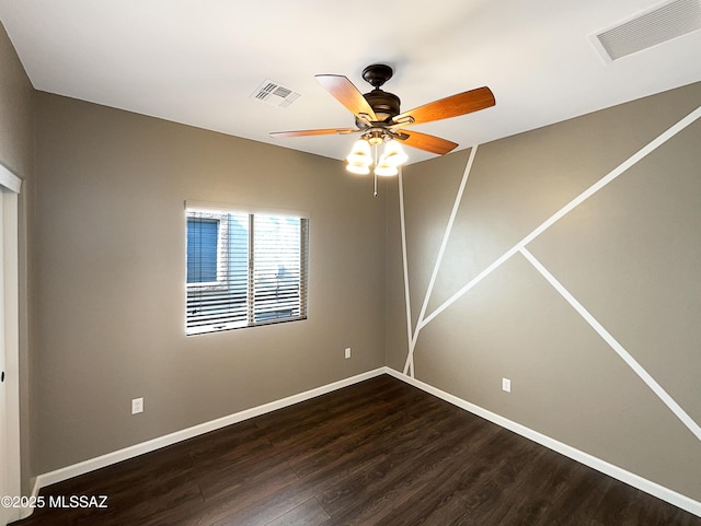 spare room with dark wood-type flooring and ceiling fan