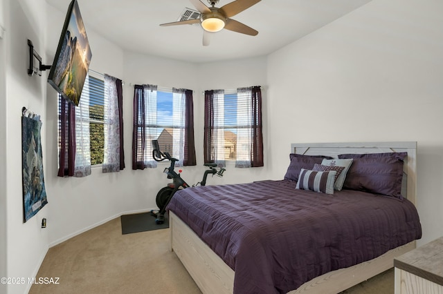 bedroom featuring multiple windows, light colored carpet, and ceiling fan