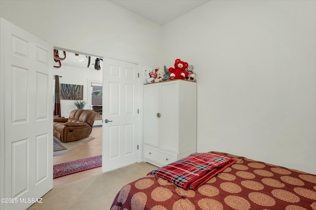 bedroom with a high ceiling and light colored carpet