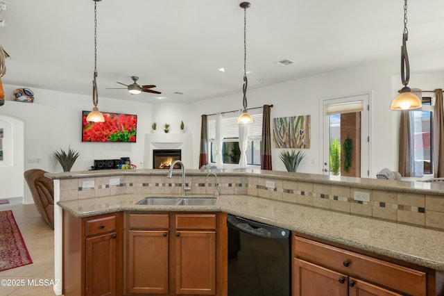 kitchen featuring tasteful backsplash, black dishwasher, sink, and hanging light fixtures