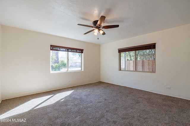 carpeted spare room featuring ceiling fan and a textured ceiling