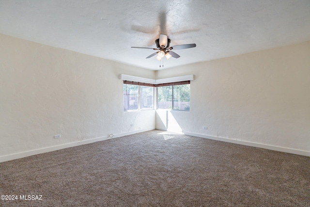 carpeted spare room featuring ceiling fan and a textured ceiling