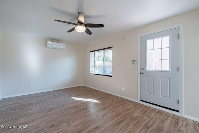 entryway with hardwood / wood-style flooring, ceiling fan, and a wall mounted air conditioner