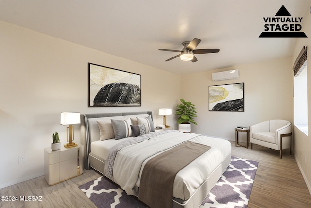 bedroom with ceiling fan, a wall mounted AC, and light wood-type flooring