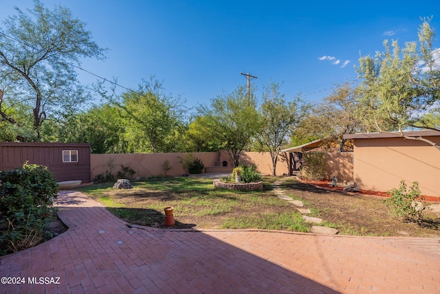 view of yard featuring a patio and an outdoor structure