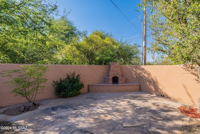 view of patio featuring an outdoor brick fireplace