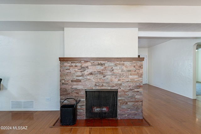 room details featuring a stone fireplace and hardwood / wood-style flooring