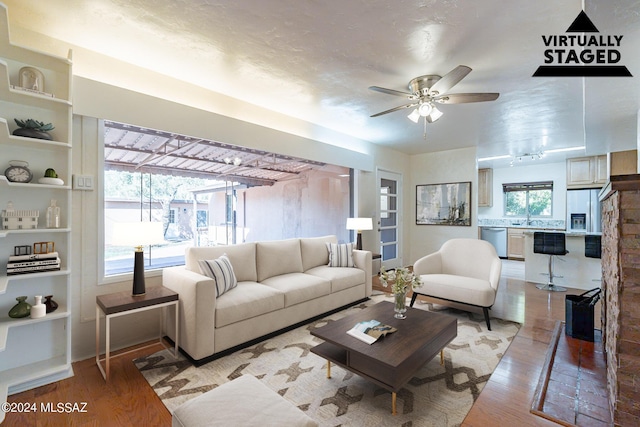 living room with ceiling fan, wood-type flooring, and sink