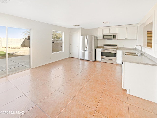 kitchen featuring stainless steel appliances, white cabinetry, sink, and light tile patterned floors