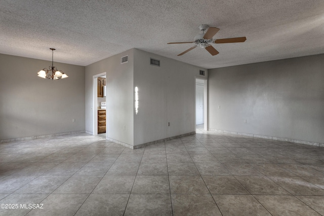 tiled spare room with ceiling fan with notable chandelier and a textured ceiling