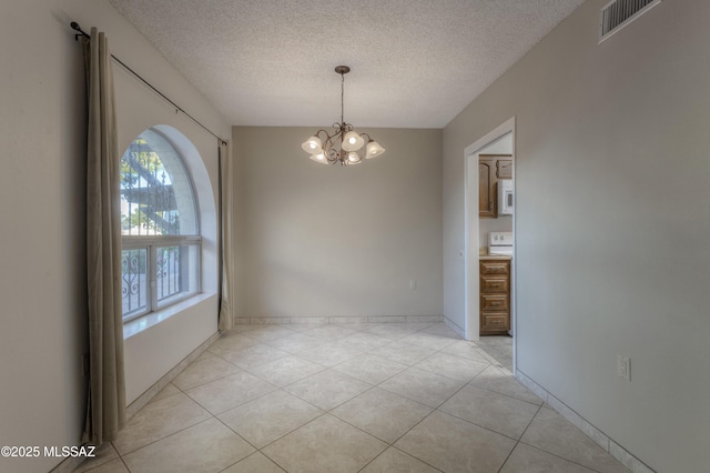 unfurnished dining area with light tile patterned floors, a notable chandelier, and a textured ceiling