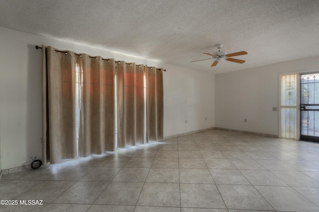 unfurnished room with ceiling fan, a textured ceiling, and light tile patterned floors