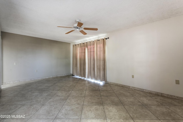 spare room with light tile patterned floors, a textured ceiling, and ceiling fan