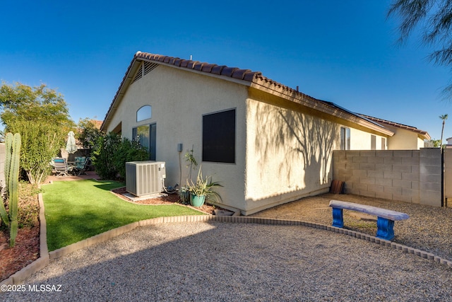 view of side of property featuring cooling unit and a lawn