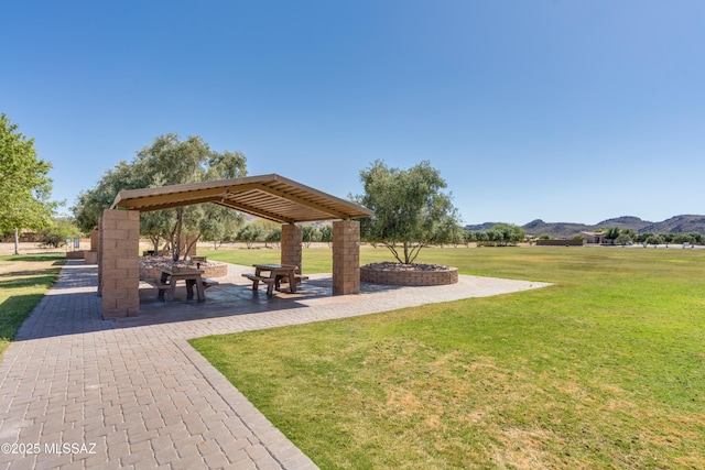 surrounding community with a gazebo, a mountain view, and a lawn