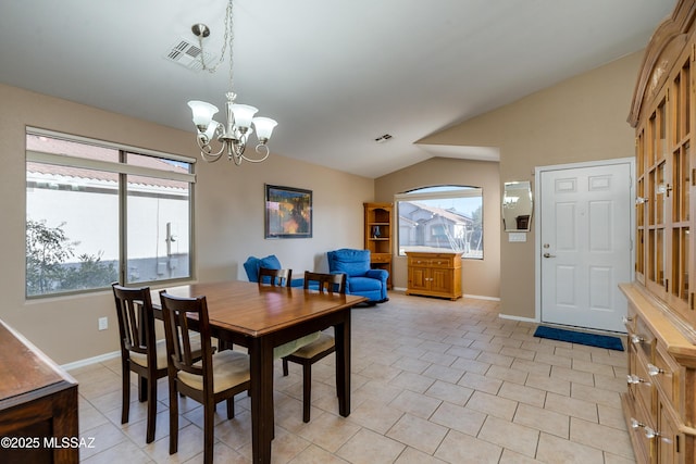 tiled dining area with lofted ceiling, a notable chandelier, and a wealth of natural light