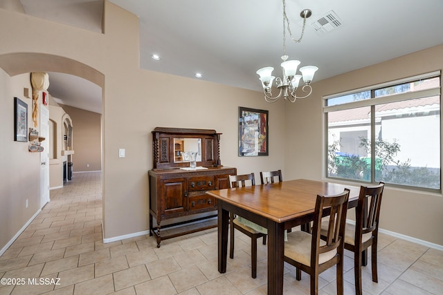 tiled dining area featuring a notable chandelier