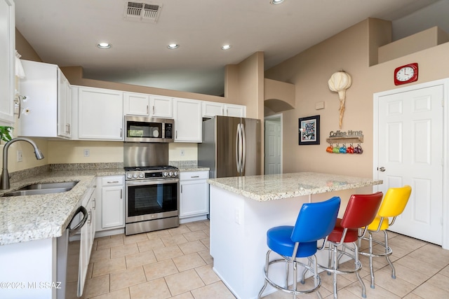 kitchen with white cabinetry, appliances with stainless steel finishes, a center island, and sink