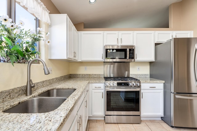 kitchen featuring stainless steel appliances, light stone countertops, sink, and white cabinets