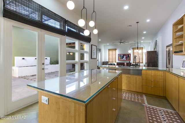 kitchen with sink, a center island, kitchen peninsula, a notable chandelier, and pendant lighting