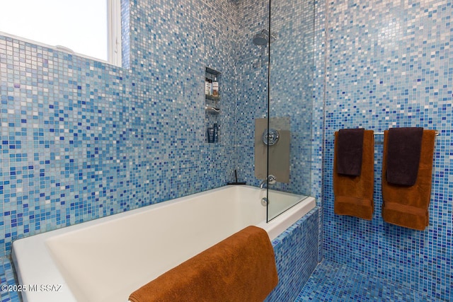 bathroom with tiled shower / bath and tile walls