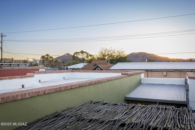 balcony at dusk featuring a mountain view