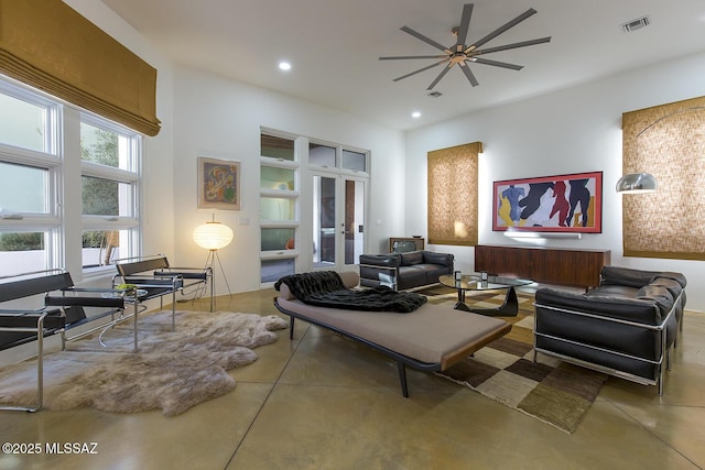 living room with concrete flooring, french doors, and ceiling fan