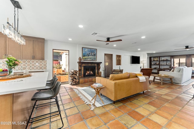 living room featuring a fireplace and ceiling fan