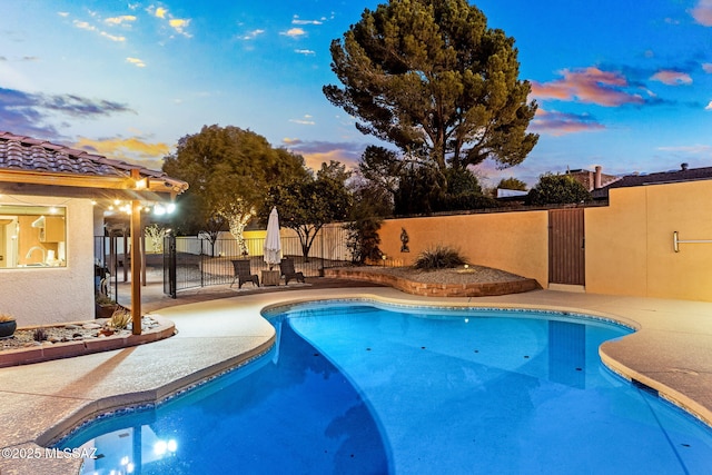 pool at dusk featuring a patio area