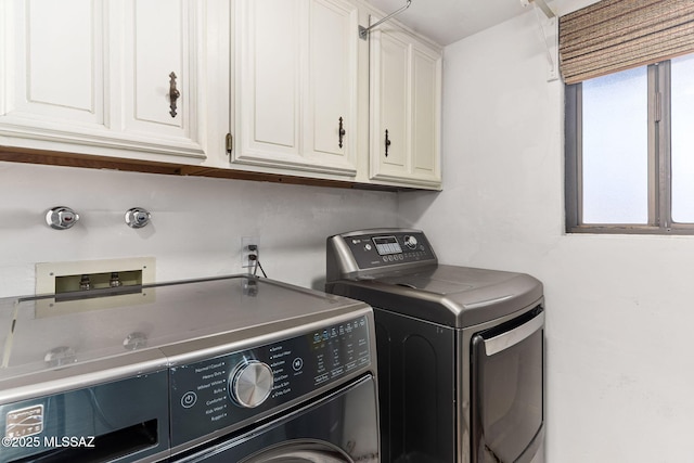 laundry room featuring cabinets, washing machine and clothes dryer, and plenty of natural light