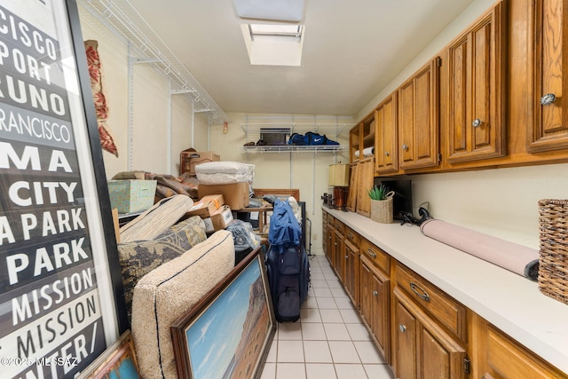 laundry area with light tile patterned flooring and a skylight