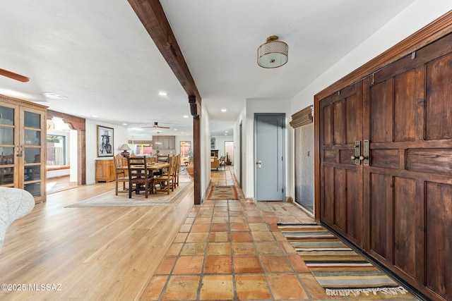 foyer with beamed ceiling, ceiling fan, and light hardwood / wood-style flooring