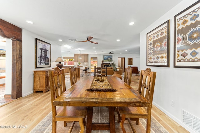 dining area with ceiling fan and light hardwood / wood-style floors