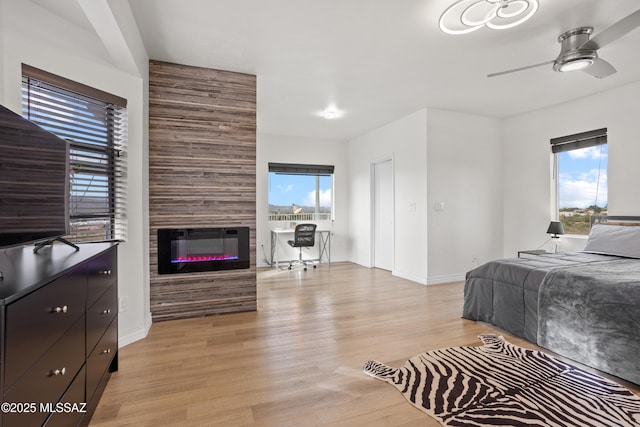 1061 W Roller Coaster Rd, Tucson, AZ 85704 - bedroom featuring light wood-style flooring, a fireplace, baseboards, and ceiling fan