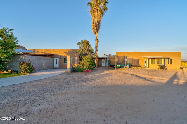 1061 W Roller Coaster Rd, Tucson, AZ 85704 - southwest-style home with a trampoline, driveway, and stucco siding