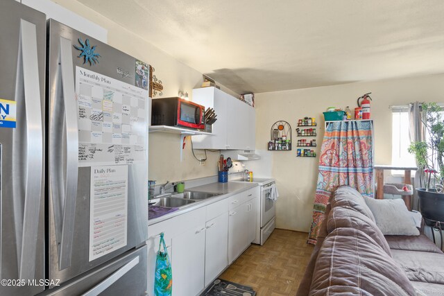 1061 W Roller Coaster Rd, Tucson, AZ 85704 - kitchen featuring white cabinets, freestanding refrigerator, electric stove, and a sink