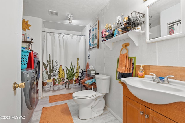 1061 W Roller Coaster Rd, Tucson, AZ 85704 - full bathroom featuring washer and clothes dryer, vanity, toilet, and tile walls