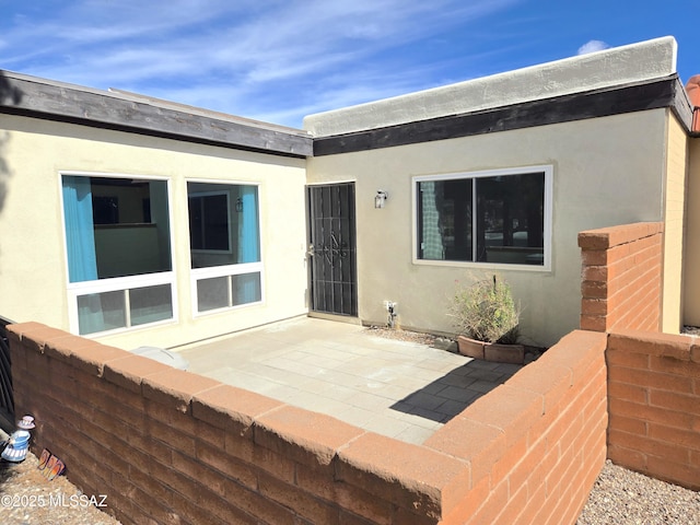 back of property featuring a patio area and stucco siding