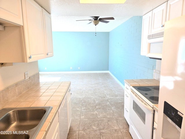 290 N Paseo De Los Conquistadores, Green Valley, AZ 85614 - kitchen with tile countertops, white appliances, ceiling fan, baseboards, and a textured ceiling